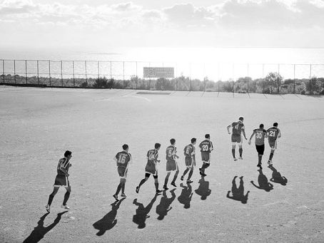 Football team running onto a pitch. Greece.